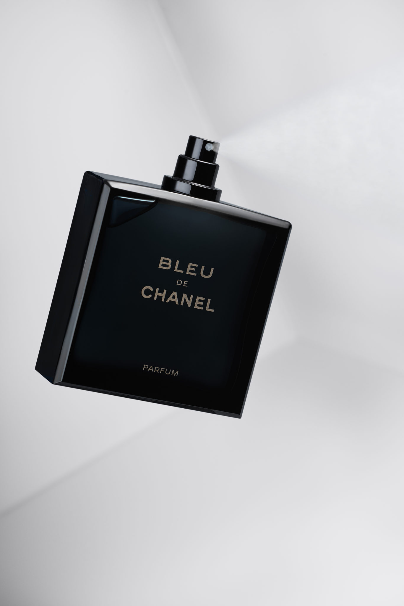 a Bleu De Chanel perfume spraying a mist shot in studio