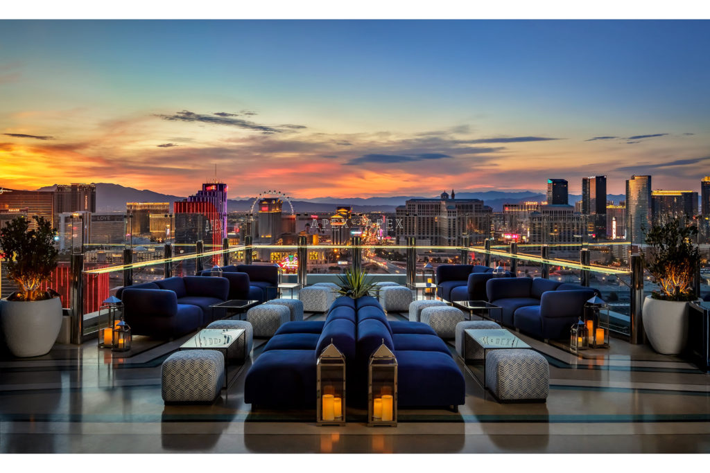 a posh lounge with a great view of the skyline at dusk